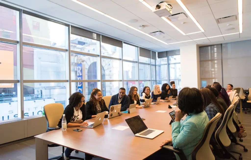 Team meeting around conference table with laptops